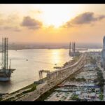 A panorama shot of a Landscape showing the coastline of Lagos Island, Nigeria at sunset, the Atlantic and a rig