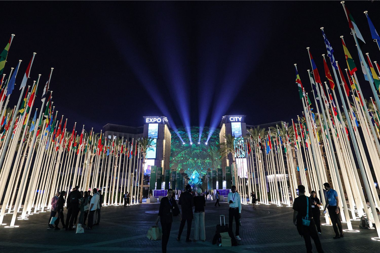 People walk outside Expo City in Dubai on December 12, 2023 during the United Nations Climate Change Conference COP28. (Photo by Giuseppe CACACE / AFP)