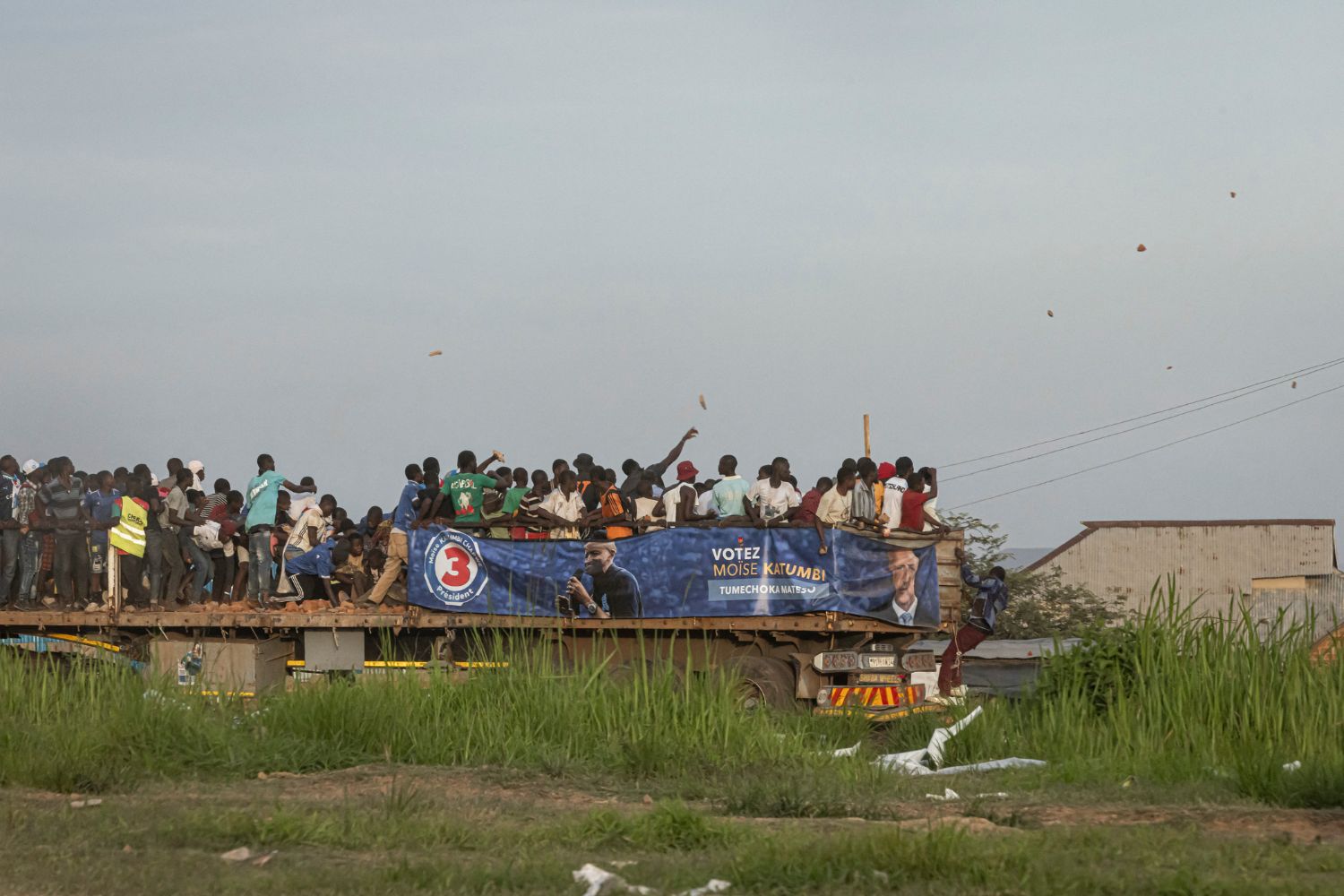 Stones are thrown form a truck in Kipushi, Democratic Republic of the Congo (DRC), on December 18, 2023, following Ensemble pour la Republique's (Together for the Republic) presidential candidate Moise Katumbi final campaign rally ahead of the upcoming elections. (Photo by Patrick Meinhardt / AFP)