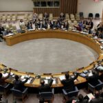 The United Nations Security Council members raise their hands to vote, Tuesday, March 22, 2011, at U.N. headquarters. (AP Photo/Richard Drew)