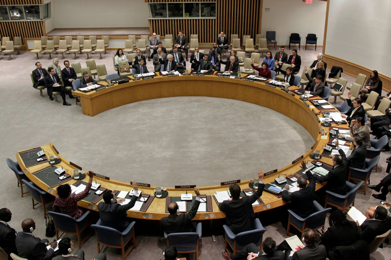 The United Nations Security Council members raise their hands to vote, Tuesday, March 22, 2011, at U.N. headquarters. (AP Photo/Richard Drew)