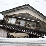 A damaged car lies underneath a collapsed building at Shika town in Hakui District, Ishikawa Prefecture on January 8, 2024 after a major 7.5 magnitude earthquake struck the Noto region on New Year's Day. (Photo by Philip FONG / AFP)c