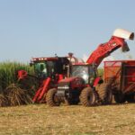 Piracicaba, Sao Paulo, Brazil - April 18,2007: A tractor and a harvester work in tandem to get sugar cane to the local mill.