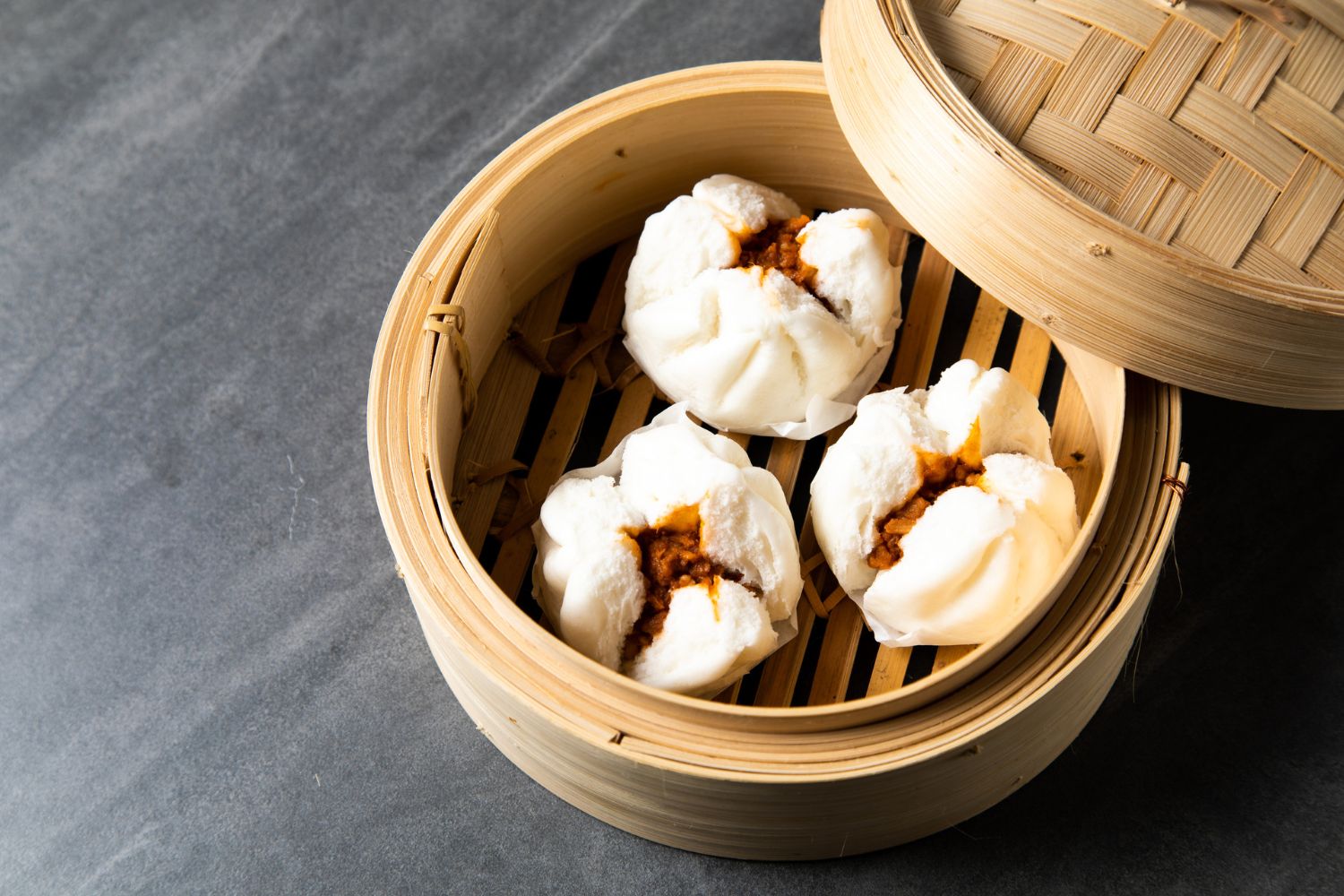 Char siu bao in a bamboo steamer