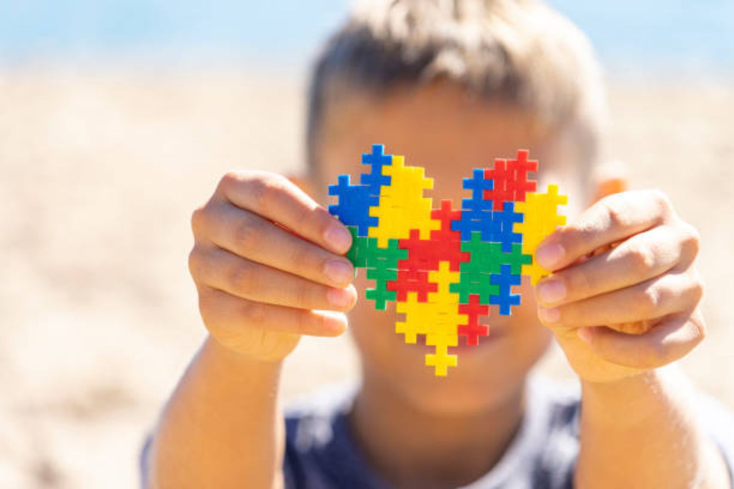 Child holds puzzle symbolising Autism Awareness