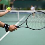 Tennis player serving tennis ball during a match on open court. Sport, training and active life concept. stock photo