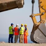 Men Standing next to an excavator