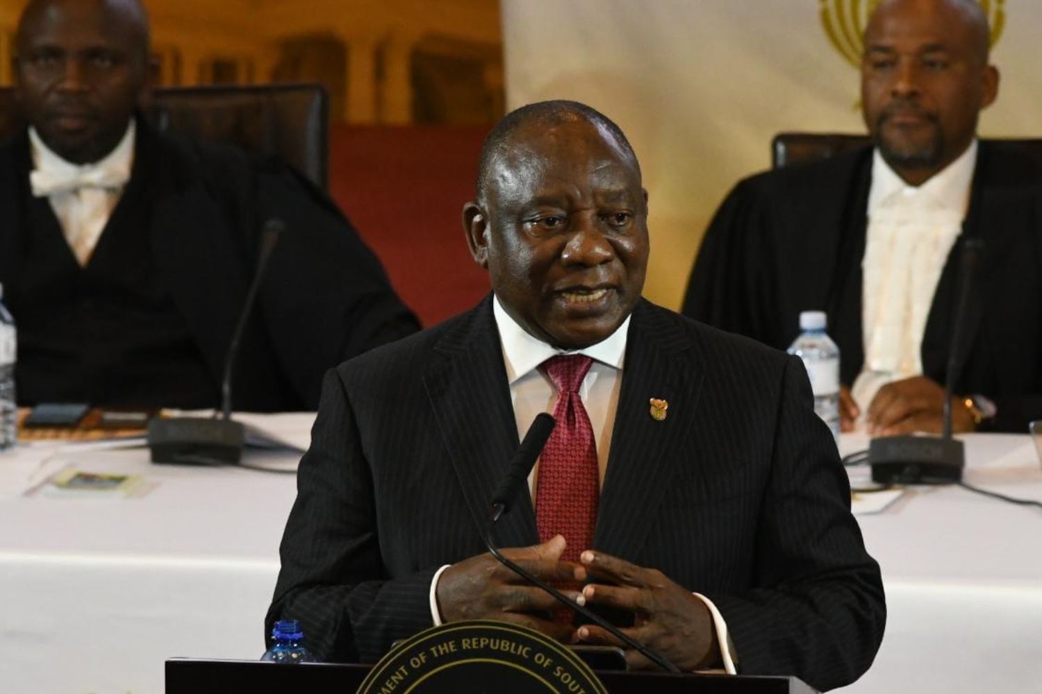 South African President Cyril Ramaphosa standing on a podium state