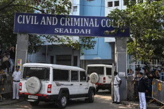 Police personnel stand guard at the entrance of the Civil and Criminal Court Sealdah in Kolkata on January 18 2025.